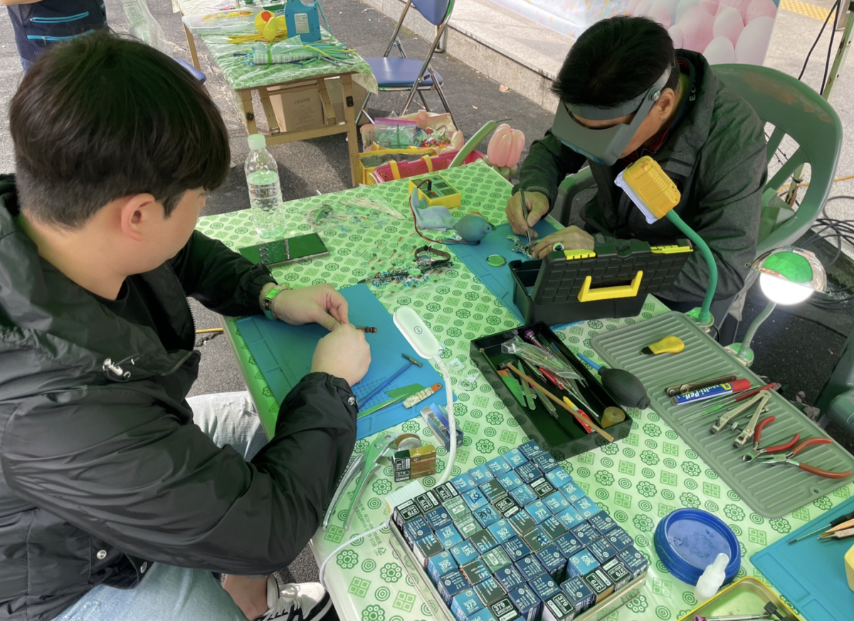 A visitor stops by a clockmaker's booth to get their watches looked at. This year, many locals offered to donate their talent to contribute to the bazaar's success. 